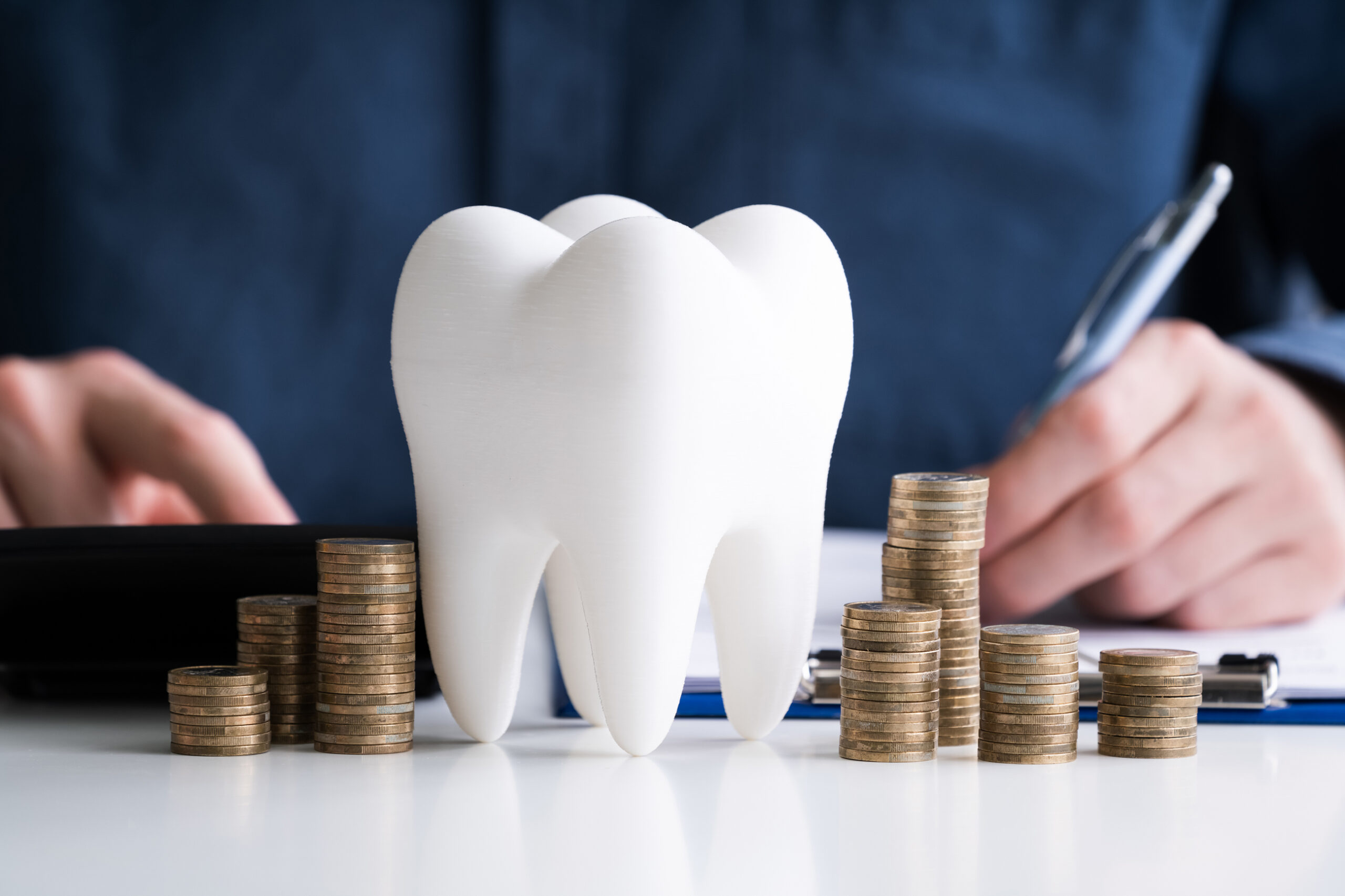 Finanzierung Zahnarztpraxis Zahn mit Münzen