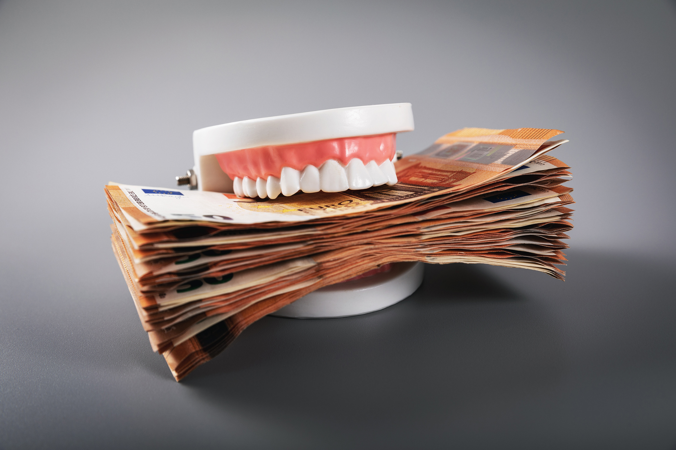 Kosten Zahnarztpraxis Gebiss mit Geldbündel